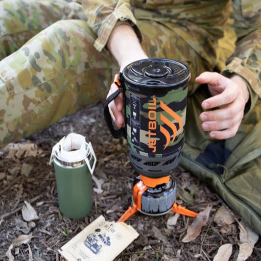 Person holding a Jetboil cooking system outdoors
